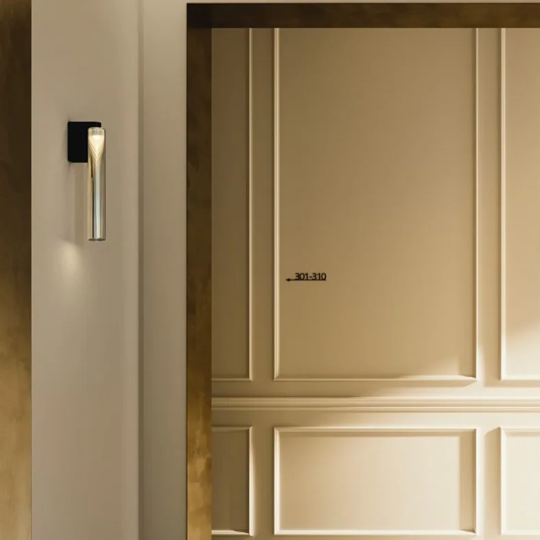 Penta: Zwei hohe schlanke Wandleuchten flankieren eine gerahmte Wandfläche in einem hellen Interieur.